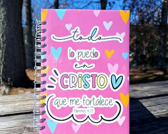 May include: Pink spiral notebook with a colorful design and the text "todo lo puedo en CRISTO que me fortalece Filipenses 4:13".