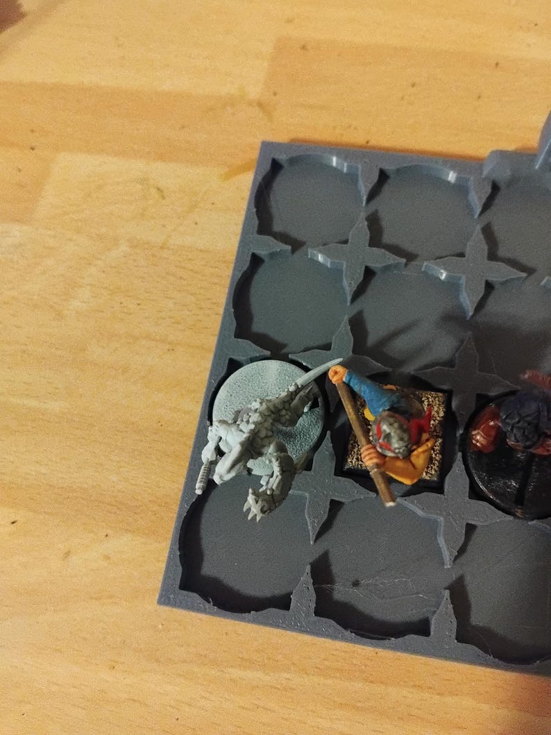 Peut inclure: Un plateau de rangement en plastique gris avec des compartiments pour figurines miniatures. Une figurine miniature grise et blanche d'une cr&eacute;ature avec une longue queue se trouve dans un compartiment. Une figurine miniature d'une personne avec une tenue rouge et jaune se trouve dans un autre compartiment. Une figurine miniature d'une cr&eacute;ature &agrave; fourrure brune se trouve dans un troisi&egrave;me compartiment.