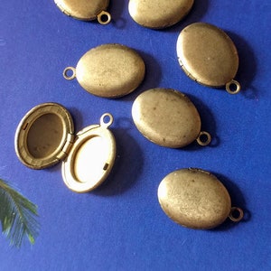 May include: Eight oval-shaped brass locket pendants with a hinged opening. The lockets have a smooth, shiny finish and come with a jump ring for attaching to a chain.