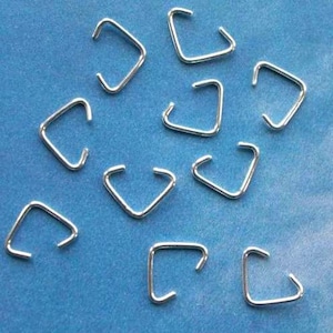 May include: A close-up of ten silver triangle jump rings. The jump rings are small and have a smooth, shiny finish.