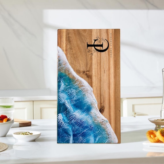 Acacia wood cutting board with a stunning hand-poured ocean wave epoxy resin inlay — no two are alike, and it's personalizable for weddings or birthdays.