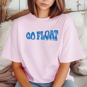 Camiseta Floatin' Go Float con ambiente de lago, río y verano para acampar en cabaña.