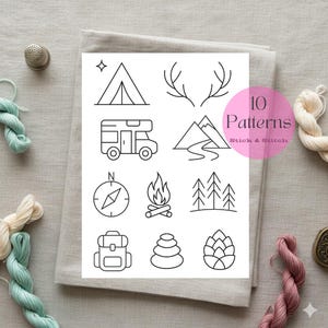 May include: A white paper with ten black line art camping-themed patterns, including a tent, camper, mountains, compass, campfire, trees, backpack, and stacked stones. The text "10 Patterns Stick & Stitch" is in a pink circle.