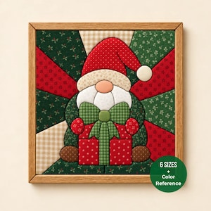 May include: A square fabric wall hanging featuring a gnome with a red hat, white beard, and green bow, holding a red gift box. The background consists of a starburst pattern in red, green, and beige fabrics. Text reads 6 SIZES + Color Reference.
