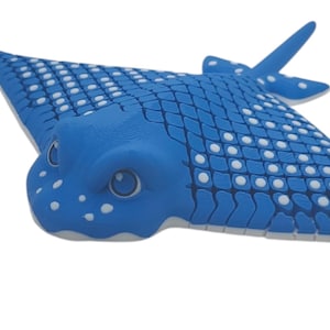 May include: A blue and white spotted stingray toy. The toy is made of soft, flexible plastic and has a realistic design.