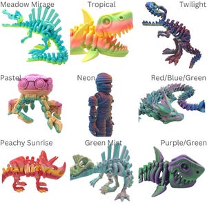 Op de afbeelding: Negen 3D-geprinte plastic dinosaurus- en dierskeletten in verschillende kleurverlopen. De skeletten zijn gerangschikt in een raster van drie rijen en drie kolommen. De kleuren omvatten pastel, neon, rood, blauw, groen, paars, perzik, geel en turquoise.