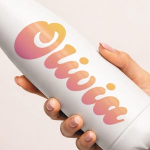 May include: White insulated water bottle with a silver cap. The bottle features the name "Olivia" in a gradient of orange and pink. The bottle is held by a person.
