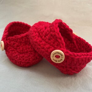 Peut inclure: Deux paniers en crochet rouge avec des boutons en bois qui disent "Handmade with love".