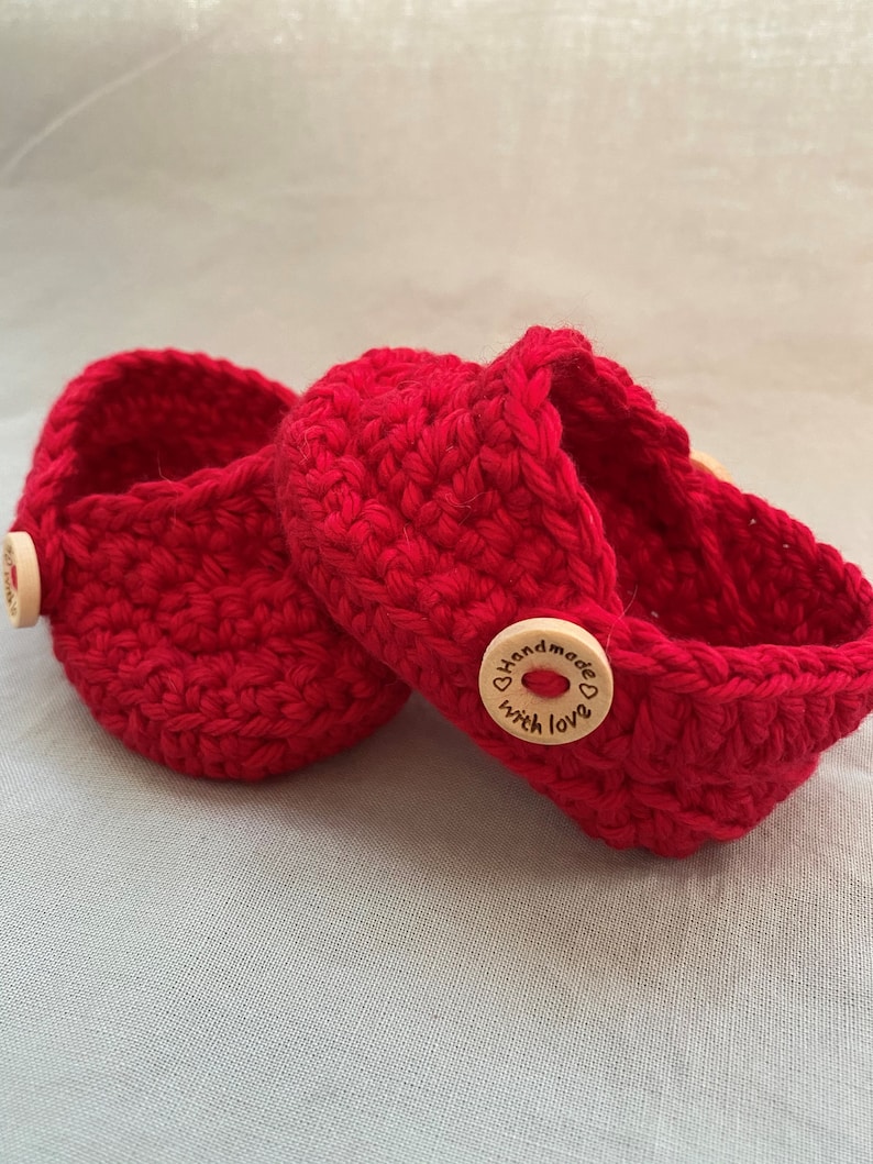 Peut inclure: Deux paniers en crochet rouge avec des boutons en bois qui disent "Handmade with love".