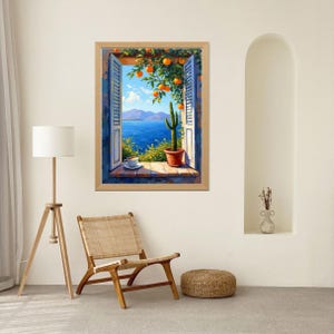 May include: A framed painting depicts a scenic view through a window. The window reveals a blue sea, mountains, and a blue sky with clouds. A cactus in a terracotta pot sits on the windowsill, with oranges hanging from a tree above.
