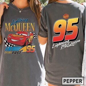 Pu&ograve; includere: T-shirt grigia con Lightning McQueen del film Cars. La parte anteriore mostra Lightning McQueen, il numero 95 e la scritta "Think Fast". Il retro presenta un grande numero 95 e la scritta "Lightning McQueen".