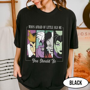 Puede incluir: Camiseta negra con un gr&aacute;fico de cuatro villanos de dibujos animados y el texto "WHO'S AFRAID OF LITTLE OLD ME - YOU SHOULD BE." El dise&ntilde;o incluye a la Reina Malvada, &Uacute;rsula, Cruella de Vil y Mal&eacute;fica. La camiseta tiene cuello redondo.