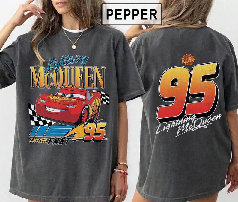 Pu&ograve; includere: T-shirt grigio scuro con Lightning McQueen del film Cars. La grafica frontale mostra l'auto da corsa rossa con la scritta "Lightning McQueen" e "95". Il retro della maglietta mostra un grande "95" e la scritta "Lightning McQueen".