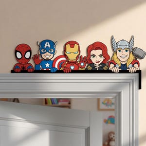 Könnte beinhalten: Ein dekorativer Türrahmenaufsatz mit fünf Comic-Superhelden: Spider-Man, Captain America, Iron Man, Black Widow und Thor mit seinem Hammer. Die Figuren sind in einer Reihe angeordnet und scheinen über die Oberkante des Türrahmens zu schauen.