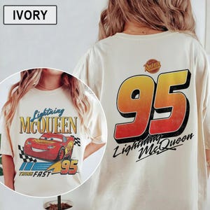 Pu&ograve; includere: T-shirt color avorio con grafica di Saetta McQueen. La parte anteriore mostra un'auto da corsa rossa, la scritta "Lightning McQueen" e "95". Il retro presenta un grande "95" con "Lightning McQueen" sotto.