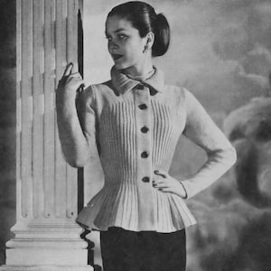 Könnte beinhalten: Ein weißer Strickcardigan mit tailliertem Oberteil und ausgestelltem Saum. Der Cardigan hat einen Kragen, einen Knopfverschluss und eine gerippte Struktur.