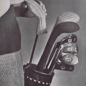 K&ouml;nnte beinhalten: Eine schwarze Ledertasche f&uuml;r Golfschl&auml;ger mit einer Rei&szlig;verschlusstasche und einem Trageriemen. Die Tasche ist gef&uuml;llt mit Golfschl&auml;gern, die jeweils mit einer wei&szlig;en gestrickten Schl&auml;gerkopf-Abdeckung versehen sind.