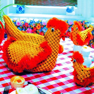 May include: Three crocheted yellow chicks with red accents. The chicks are sitting on a red and white checked tablecloth.