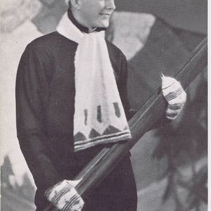 K&ouml;nnte beinhalten: Ein Schwarzwei&szlig;foto einer Person, die eine wei&szlig;e Strickm&uuml;tze und einen Schal mit geometrischem Muster tr&auml;gt. Die Person h&auml;lt ein Paar Ski.