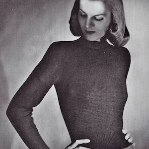 Peut inclure: Un pull noir à col roulé à manches longues et à silhouette ajustée. Le pull est en tissu doux et tricoté.