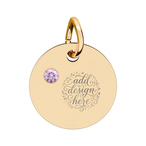 Puede incluir: Un colgante circular de tono dorado con una pequeña piedra preciosa redonda de color violeta claro en el lado izquierdo. La superficie muestra el texto grabado "add design here" rodeado por un delicado patrón de corona floral y una anilla dorada.