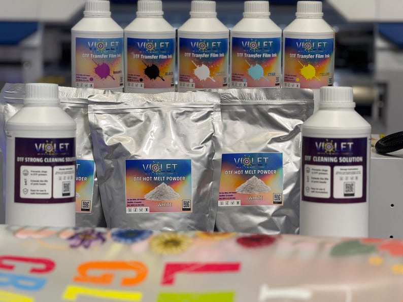 May include: A set of DIY heat transfer supplies including six bottles of colored ink, two bags of white hot melt powder, and two bottles of cleaning solution. The bottles are labeled "Violet" and the bags are labeled "Violet Die Hot Melt Powder".