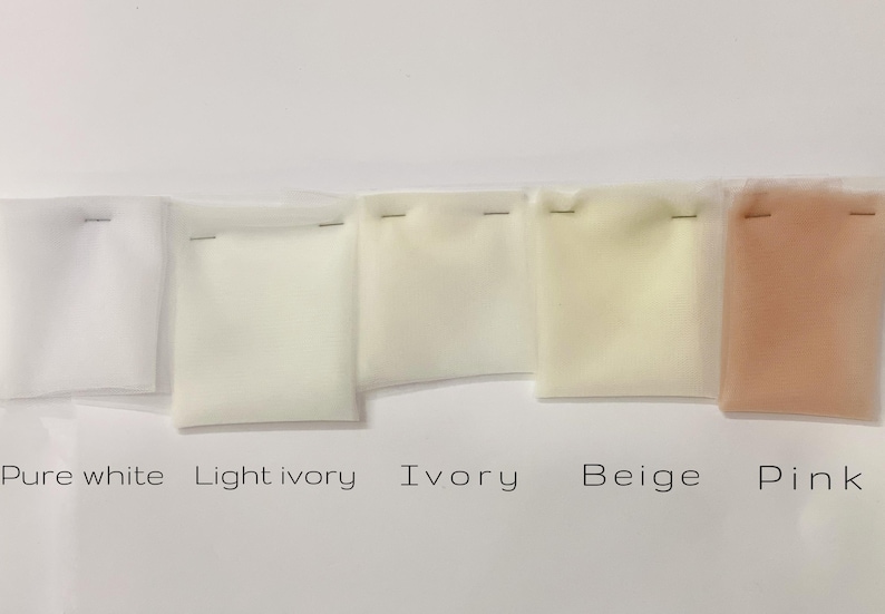 May include: A collection of fabric swatches in shades of white, ivory, beige, and pink, labeled "Pure white," "Light ivory," "Ivory," "Beige," and "Pink." Each swatch is stapled to a small square of clear plastic.