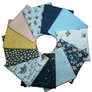 May include: A collection of folded fabric squares in various patterns and colors, arranged in a circular shape. Designs include bees, flowers, stars, and abstract patterns in shades of blue, yellow, pink, and white. Ideal for quilting or crafting projects.