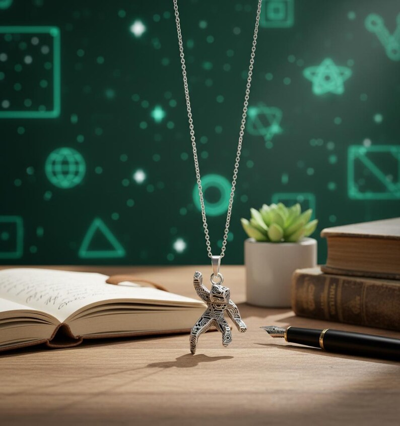 Pu&ograve; includere: Collana con pendente in argento con un design dettagliato di astronauta. Il pendente &egrave; appeso a una catena delicata. Lo sfondo include un libro, una penna e una piccola pianta in vaso, il tutto su una superficie di legno.