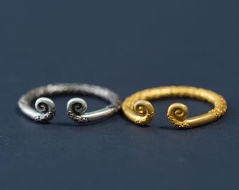 May include: Two silver and gold bracelets with a textured finish and a spiral design on the ends.