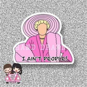 May include: A pink sticker with a cartoon illustration of a woman wearing a pink robe, a large pink hat, and a fluffy pink scarf. The text "I ain't people!" is written in black letters below the woman.