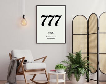 Könnte beinhalten: Ein Schwarzweißdruck mit der Zahl 777 und dem Wort "LUCK" mit dem Text "Wonderful things are about to happen". Der Druck hängt an einer weißen Wand in einem Wohnzimmer mit einem Schaukelstuhl, einer Pflanze und einem Beistelltisch.