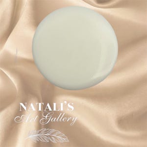 May include: A smooth, off-white, spherical object, possibly a decorative element or art piece, is centered against a backdrop of draped, satin-like fabric. The text "NATALI'S Art Gallery" is displayed in elegant script.