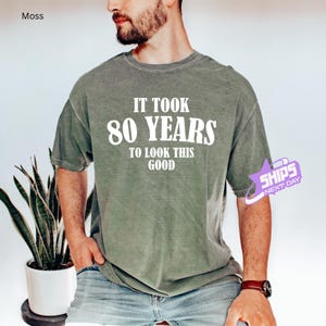May include: A green t-shirt with the text "It took 80 years to look this good" printed in white.