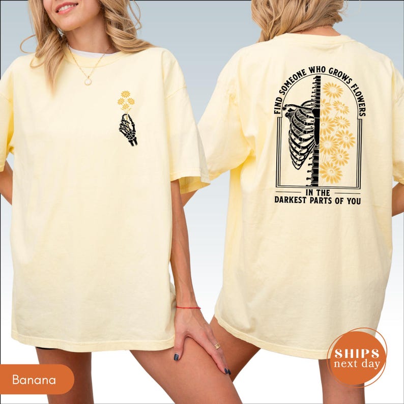 A woman wearing a yellow t-shirt with a graphic design on the back.