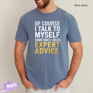 a man wearing a blue t - shirt that says of course i talk to my