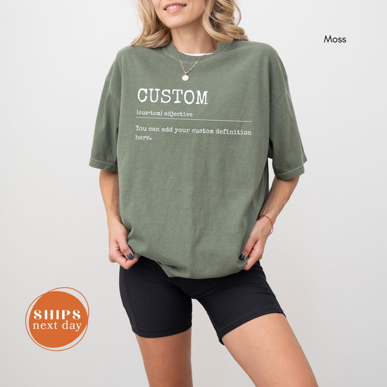 A woman wearing a green t-shirt with the word "CUSTOM" printed on it, standing against a white background.