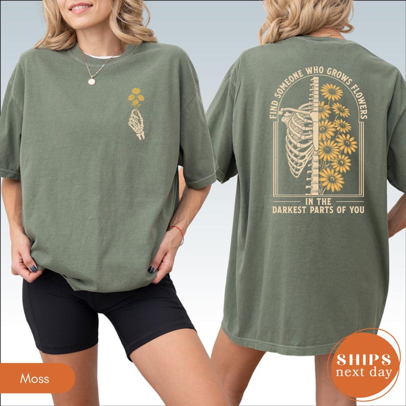 A woman wearing a green t-shirt with a graphic design on the back.