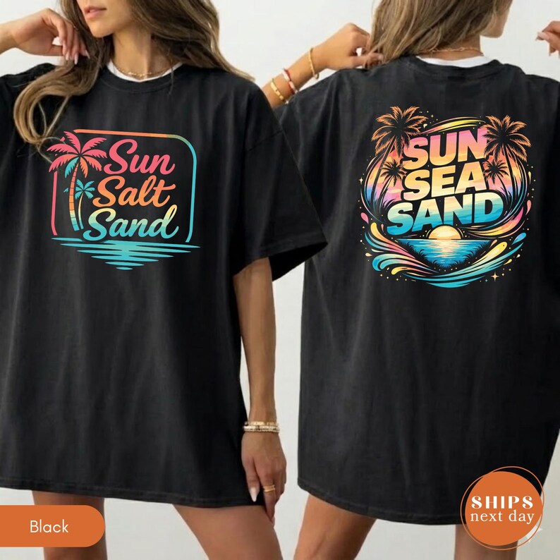 May include: A black t-shirt featuring a graphic on the front and back. The front graphic shows a palm tree and the text Sun Salt Sand in a rectangular frame. The back graphic displays palm trees, waves, and the text Sun Sea Sand in colors.
