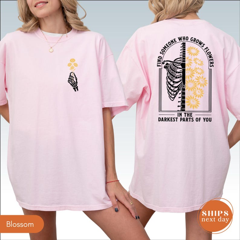 A woman wearing a pink t-shirt with a graphic design on the back.