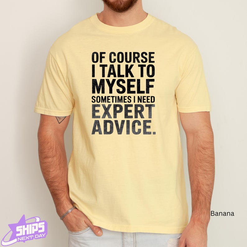 a man wearing a yellow t - shirt that says of course i talk to my