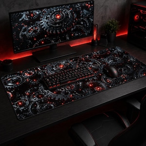 Può includere: Un'impostazione di gioco nera e rossa con un design a ingranaggi. L'impostazione include un ampio tappetino per mouse, una tastiera e un monitor. Il tappetino per mouse e il monitor mostrano un motivo ripetuto di ingranaggi con accenti rossi.