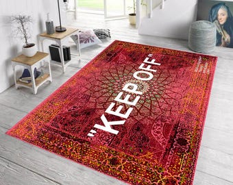 Könnte beinhalten: Ein rechteckiger roter Teppich mit einem detaillierten geometrischen Muster und den Worten "KEEP OFF" in großen weißen Buchstaben. Der Teppich hat ein zentrales Medaillon-Design und einen dekorativen Rand, geeignet für ein Wohn- oder Schlafzimmer.