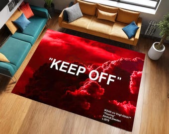 Könnte beinhalten: Ein roter, rechteckiger Teppich mit Wolkenmuster und dem weißen Schriftzug "KEEP OFF". Der Teppich ist Teil der IKEA c/o Virgil Abloh "Flooring" Kollektion, hergestellt in Almhult, Schweden, im Jahr 2019.
