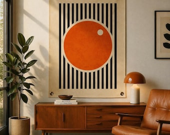 May include: A large wall hanging featuring an orange circle with a white dot, set against black vertical stripes. The artwork is mounted on a beige background with metal grommets. The piece is part of a modern home decor theme.