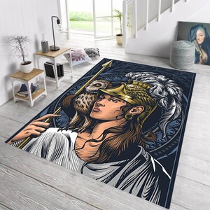 Op de afbeelding: Een rechthoekig vloerkleed met een gedetailleerde illustratie van een persoon met een gouden helm en een speer, met een uil op de schouder. Het kleed heeft een donkerblauwe achtergrond en een decoratieve rand.