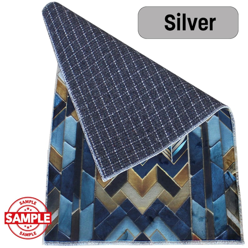 May include: A rectangular rug with a geometric pattern in shades of blue, gold, and teal. The rug's underside is a dark gray with a grid pattern. The word "Silver" is in a gray rectangle. The word "SAMPLE" is stamped on the rug.