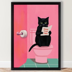 Op de afbeelding: Een zwarte kat die op een roze toilet zit met een bordje waarop staat "Was je poten". De kat houdt het bordje in zijn poten en kijkt naar de kijker. Het toilet bevindt zich in een roze badkamer met een roze deur en een rol toiletpapier.