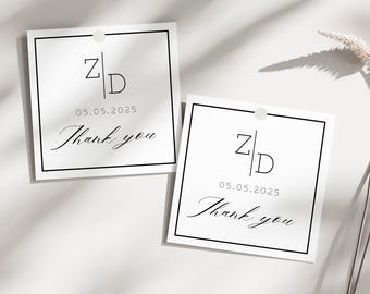 May include: Two white square tags with black borders and a hole at the top. Each tag features the initials "Z|D", the date "05.05.2025", and the words "Thank you" in elegant script. The tags are on a white surface.
