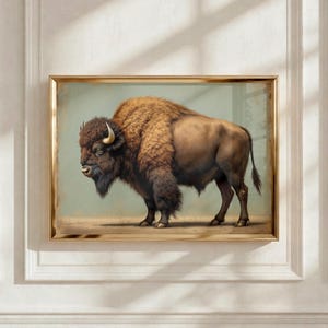 May include: A framed wall art print featuring a side profile illustration of a brown American bison with thick fur, a prominent hump, and curved horns, set against a muted light green background within a metallic gold frame.
